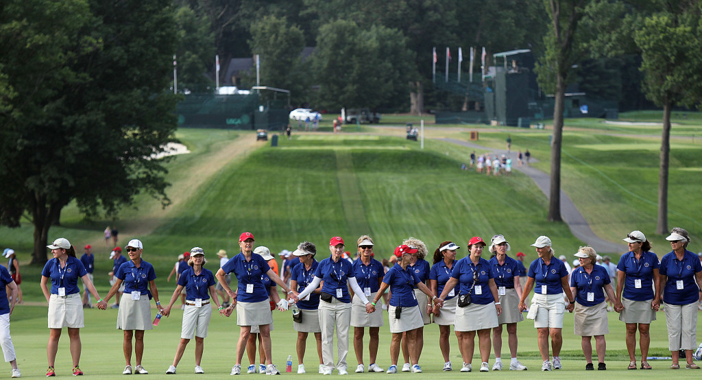 Female volunteers stand hand in hand across the 18th fairway, during the trophy presentation of the 70th US Women's Open at Lancaster Country Club Sunday July 12, 2015. (Photo/Chris Knight)
