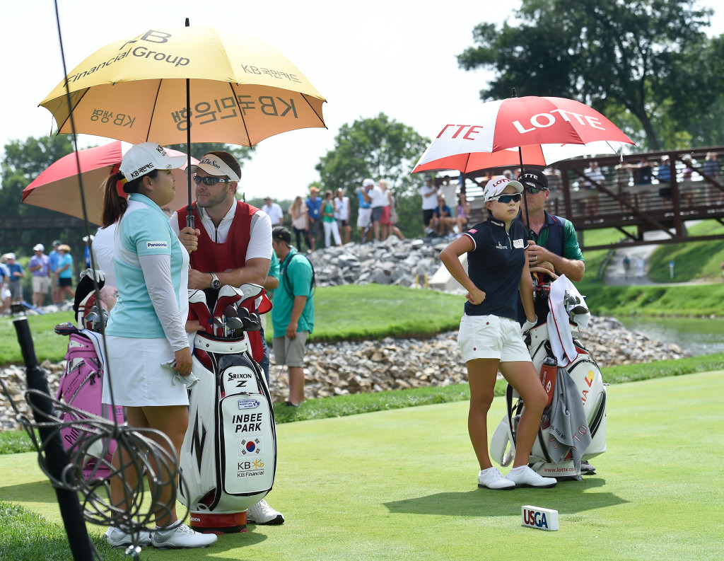 Inbee Park and Sei Young Kim and caddies, try to keep cool as the wait to hit their tee shots on number seven during the opening round of the US Women's Open at Lancaster Country Club on Thursday, July 9, 2015. (Photo/Suzette Wenger)