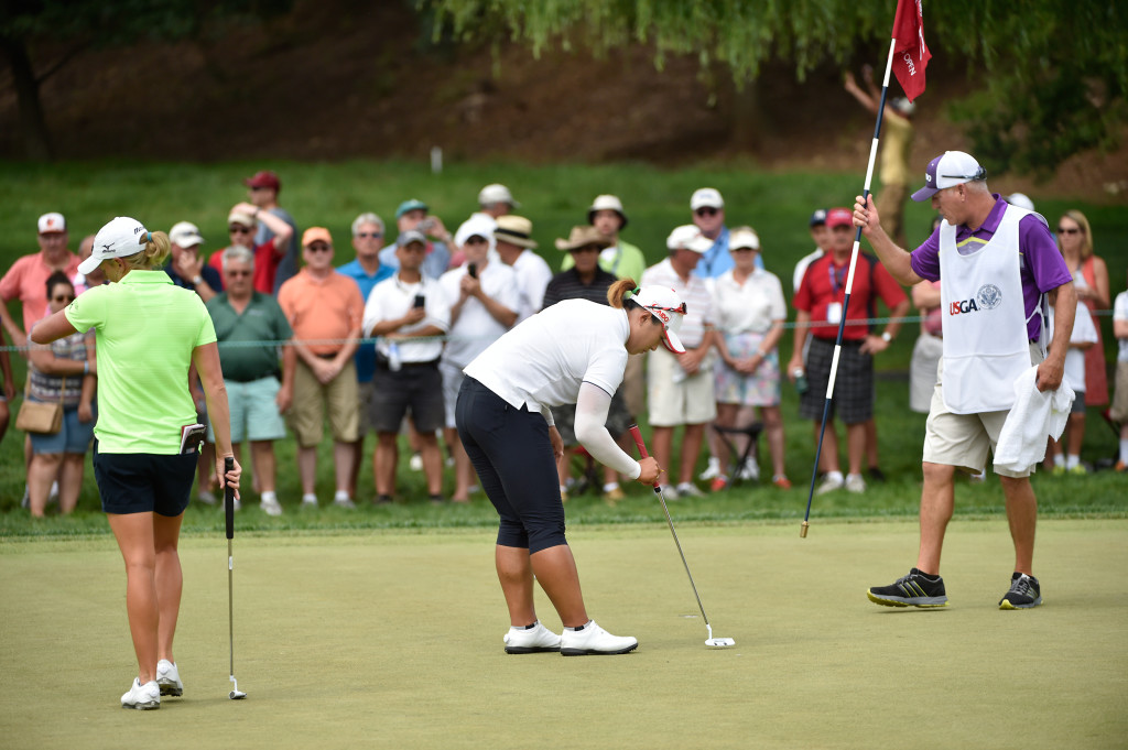 Amy Yang, center, fixes her ball mark on the fifth hole as Stacy Lewis, left, tries to recover after hitting her second shot into Stauffer Run and taking a double bogie during the final round of the US Women's Open at Lancaster Country Club on Sunday, July 12, 2015. (Photo/Suzette Wenger)